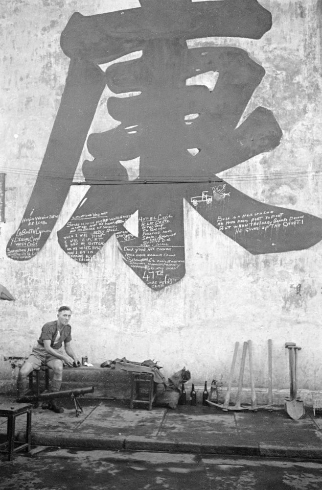 【JPG清晰版】._上海，一名男子坐在带有涂鸦的建筑物旁