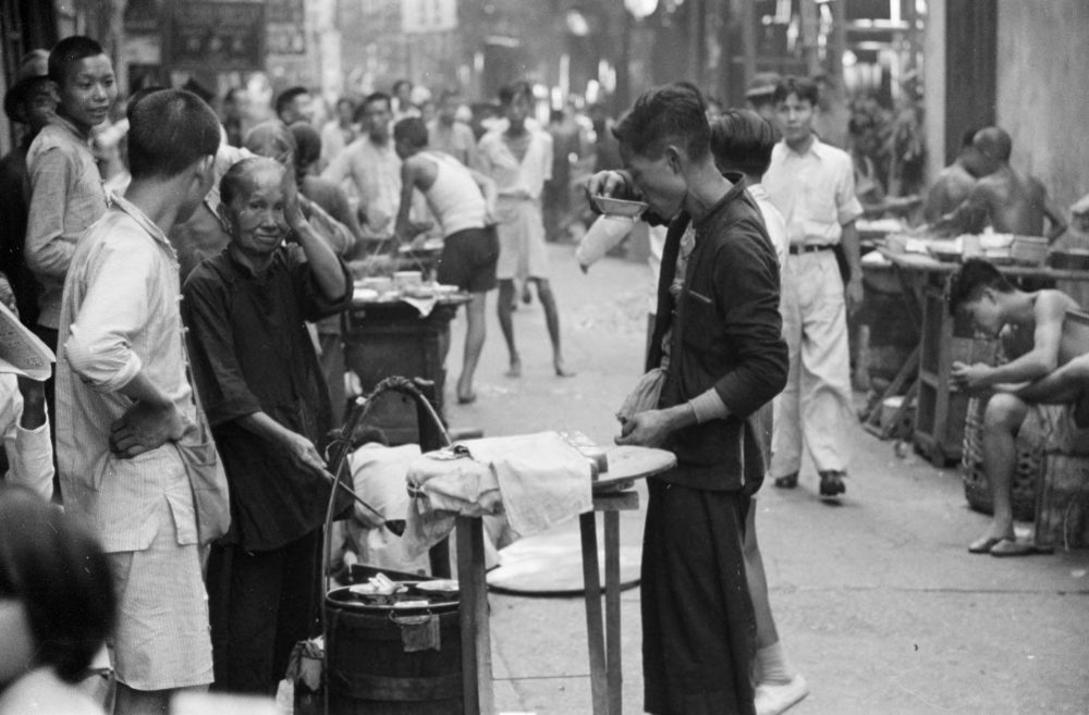 【JPG清晰版】._香港，一名男子正在吃街头小贩卖的一碗食物