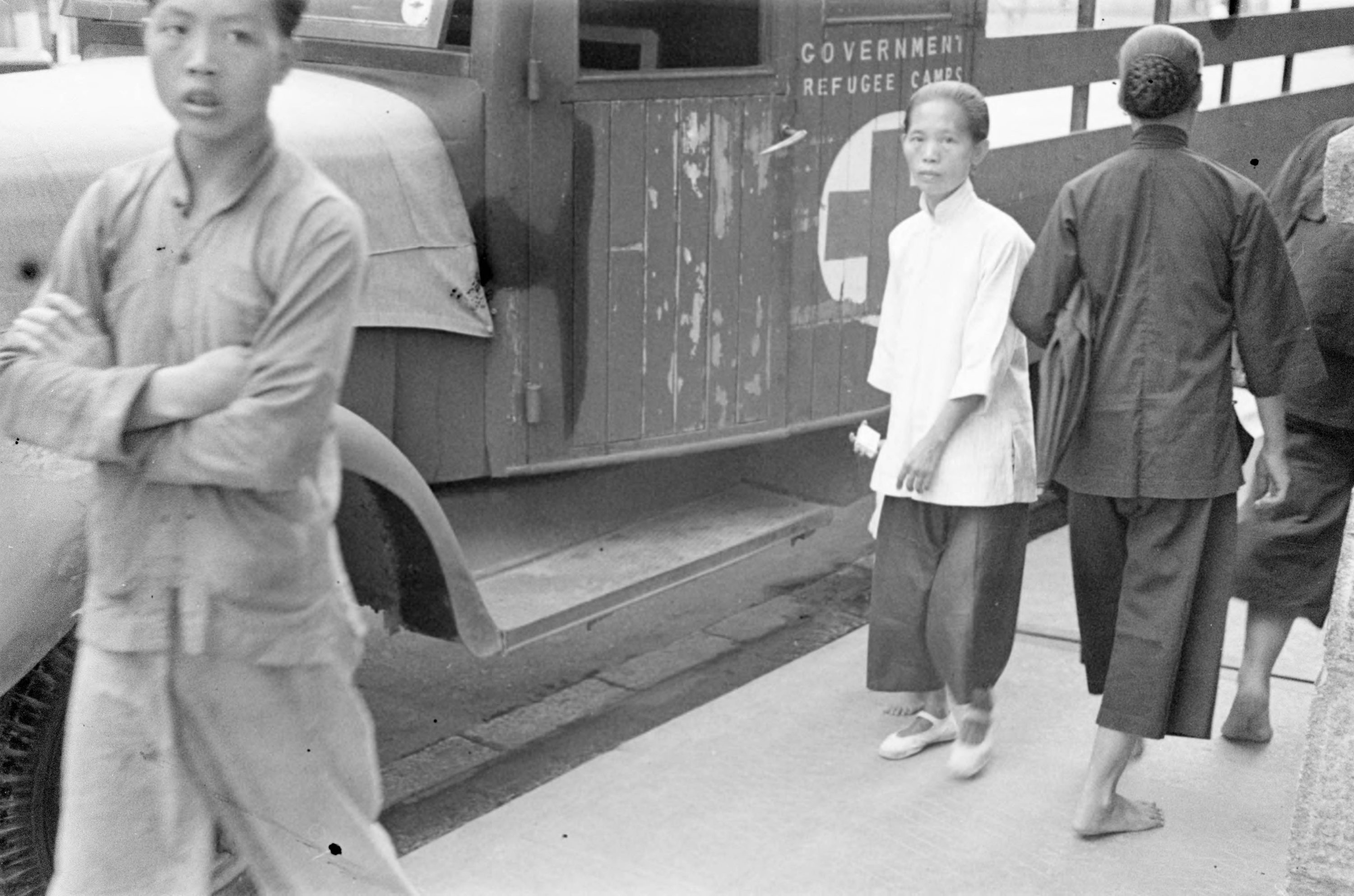 【JPG清晰版】._香港，人们走过政府难民营卡车