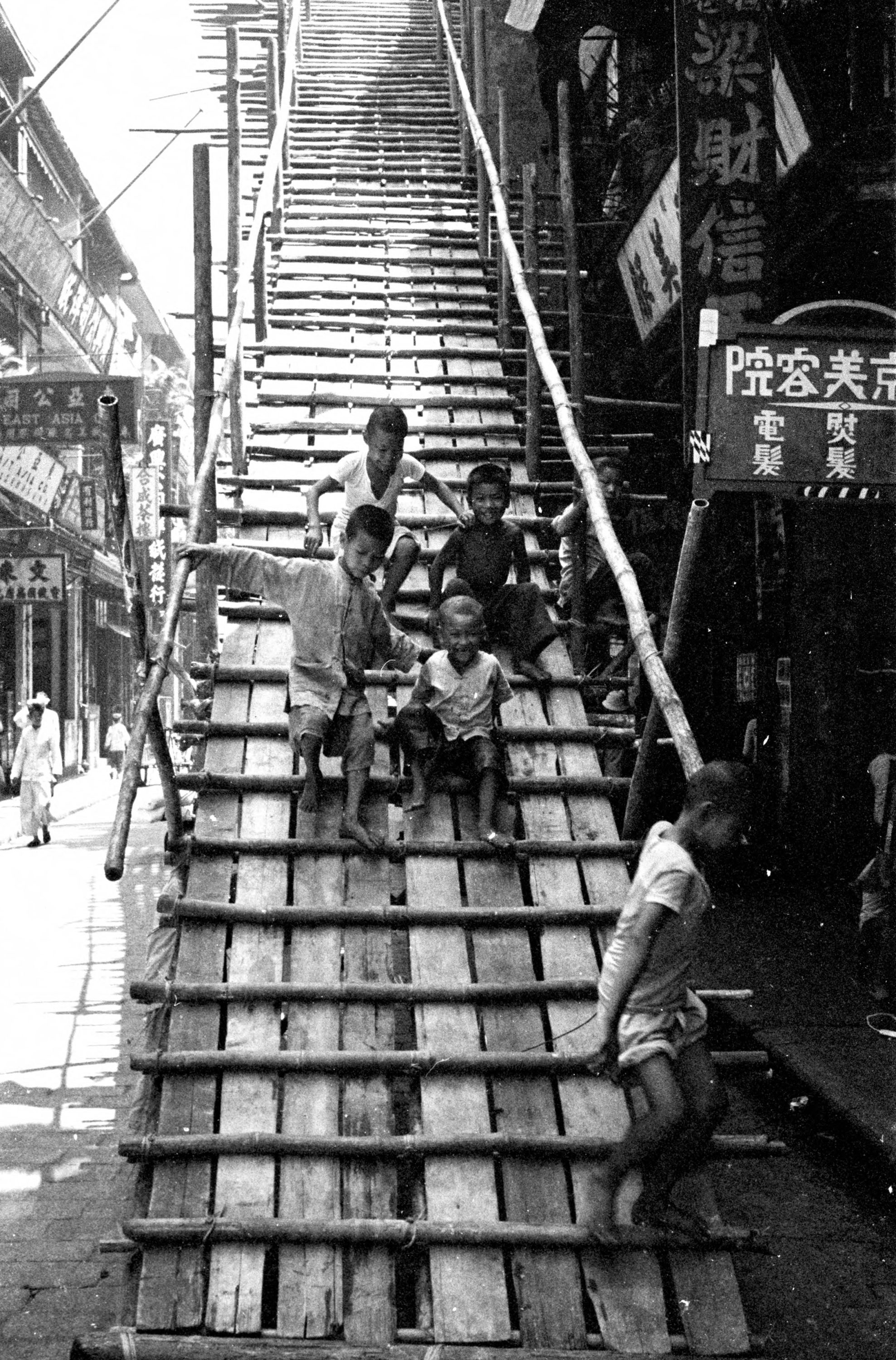 【JPG清晰版】._香港，孩子们在商店前的木制脚手架上玩耍
