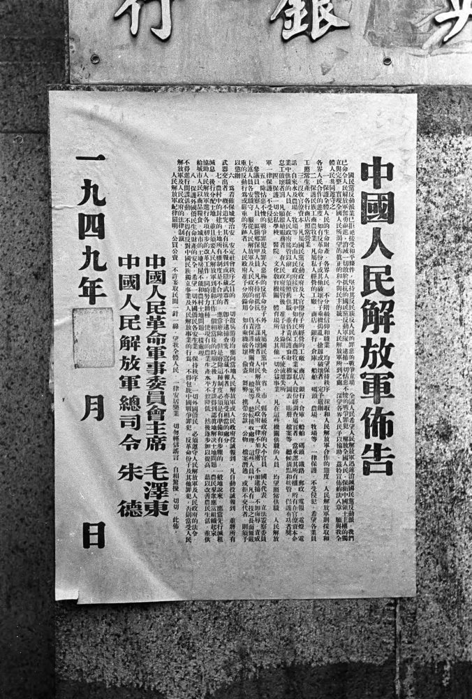 【JPG清晰版】._年内战期间，上海建筑物上张贴的宣传海报被路人阅读