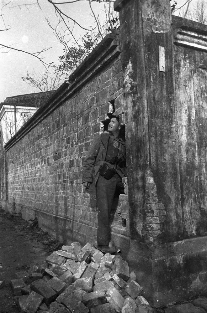 【JPG清晰版】._桃园，一名战地记者在日军轰炸后，在天主教堂庭院墙壁上的一个洞里拍照