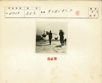 两人扛竹竿行走土路.jpg