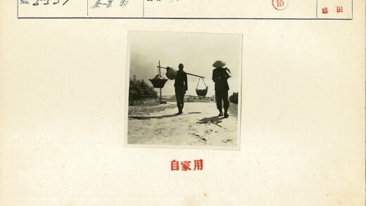 两人扛竹竿行走土路.jpg