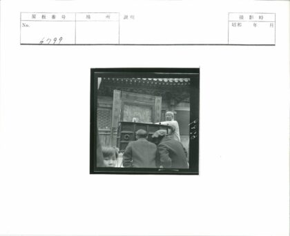 传统建筑前展示艺术品与孩童.jpg