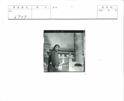 传统建筑旁持包女子与石柱.jpg