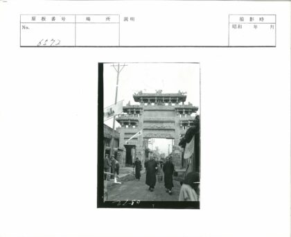传统建筑石门街景与行人.jpg