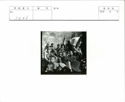 儿童聚集砖墙旁举旗活动.jpg