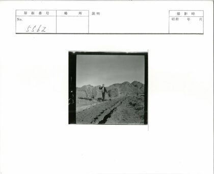 农夫携工具行走田野群山晴空.jpg