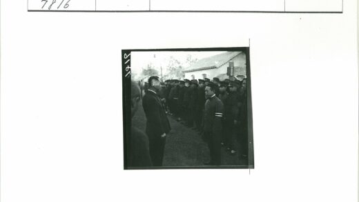 制服男子砖瓦建筑前站立.jpg