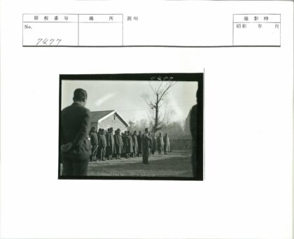 制服队伍与西装男子在砖楼前.jpg