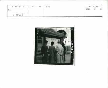 四人砖墙前看公告.jpg