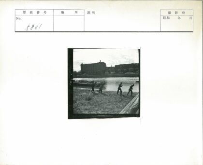 多云天空下沙岸拉船与建筑.jpg