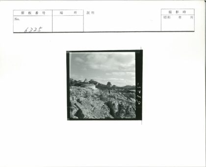 多云天空下的岩石古建亭台.jpg