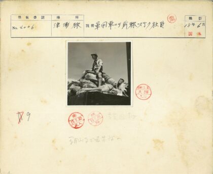 头盔人坐袋堆晴空下.jpg