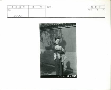 女人抱狗树影墙前.jpg