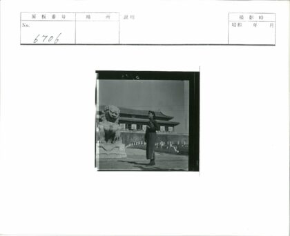 女子与石狮子雕像前建筑景观.jpg