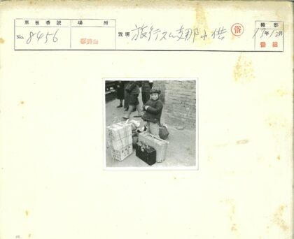 孩子与行李站在砖墙前.jpg
