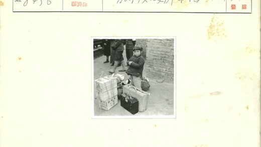 孩子与行李站在砖墙前.jpg