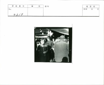 戴眼镜妇女在繁忙露天市场.jpg