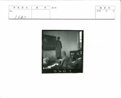 教室黑板旁老师指导学生写字.jpg