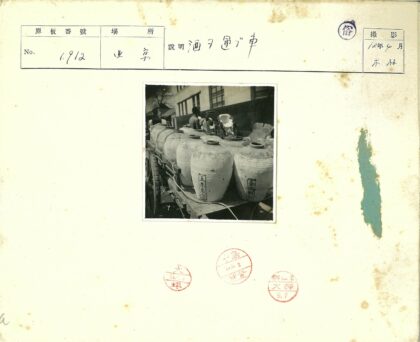 木车上的陶瓷罐与人像建筑背景.jpg