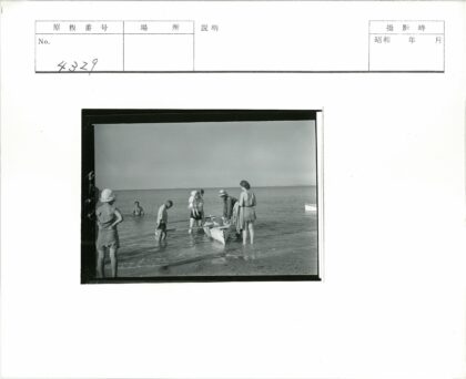 海岸线浅水区人群围船.jpg