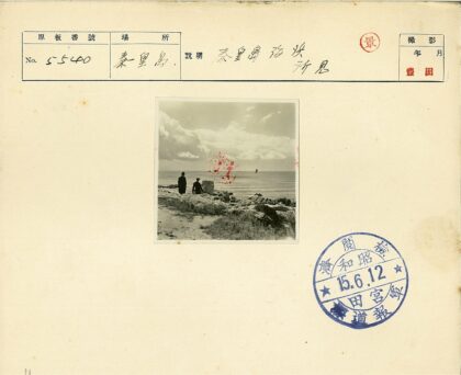 海边岩石上的两人与帆船.jpg