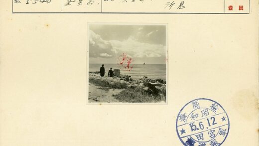 海边岩石上的两人与帆船.jpg