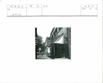 男子骑自行车经过遮阳篷建筑.jpg