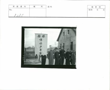 男孩举横幅在砖建筑前合影.jpg