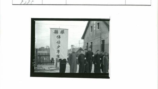男孩举横幅在砖建筑前合影.jpg
