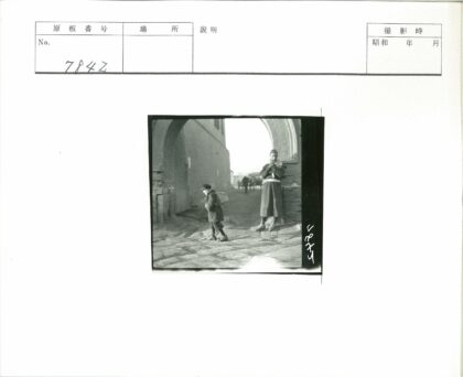 男孩背包走过拱门街景.jpg