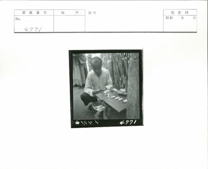 白衬衫男子竹编墙前摆物件.jpg