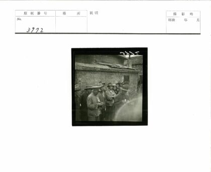 砖房前戴帽夹克男子群像.jpg
