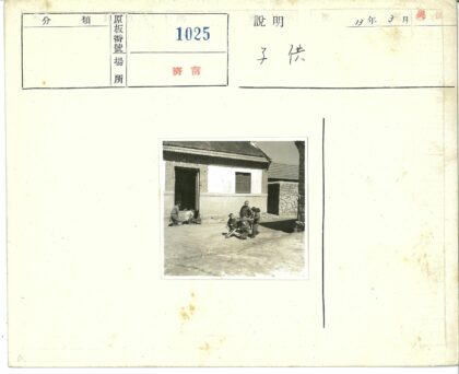 砖房旁孩童玩木制手推车.jpg