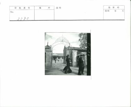 行人走过锻铁大门与传统建筑.jpg