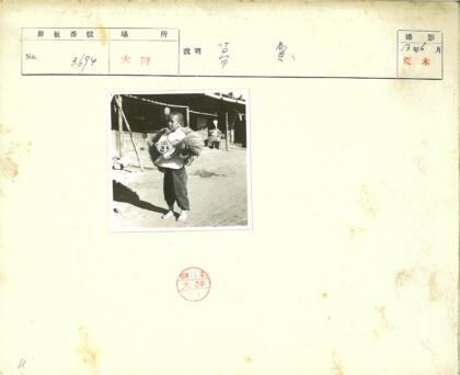 赤脚男孩持谷物泥路背影.jpg