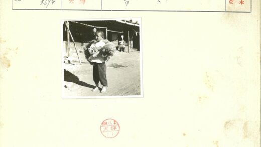 赤脚男孩持谷物泥路背影.jpg