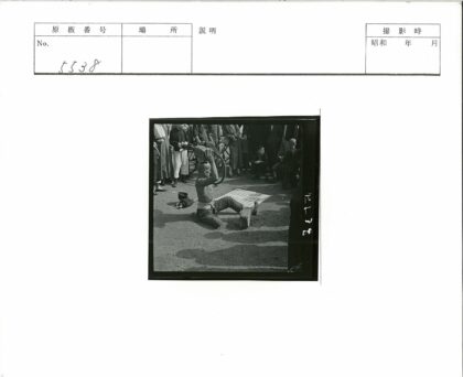 赤膊男子跪地顶砖群众围观.jpg
