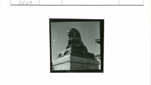 雄伟石狮与传统建筑蓝天背景.jpg