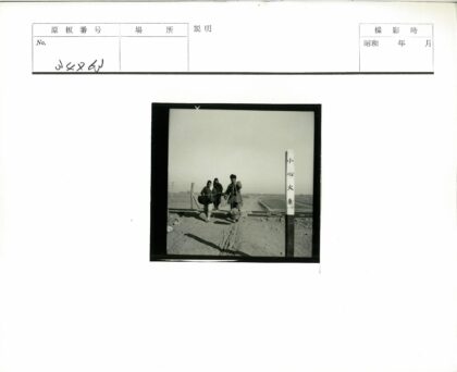 三人扛篮行走铁轨旁田野.jpg