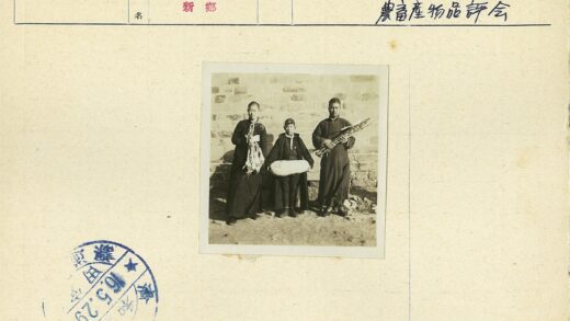 三人持物立于石墙前.jpg