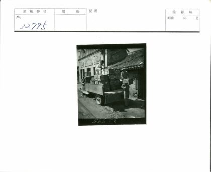 三人装货旧卡车土路旁建筑.jpg