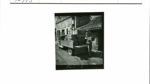 三人装货旧卡车土路旁建筑.jpg