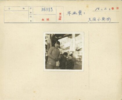 三童站墙前穿夹克戴帽.jpg