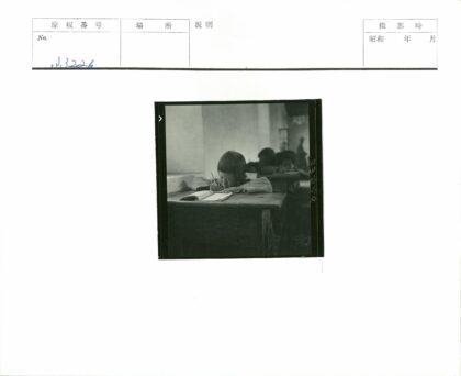 专心写笔记的学生在木桌前.jpg