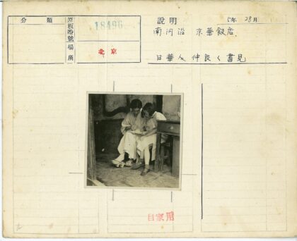 两人共坐木凳写作场景.jpg