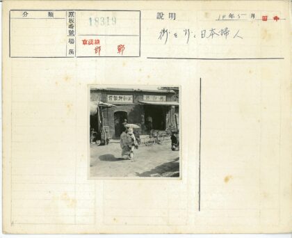 两人撑伞走过砖房自行车旁.jpg