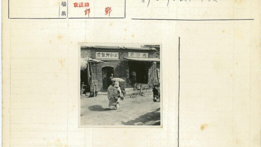 两人撑伞走过砖房自行车旁.jpg